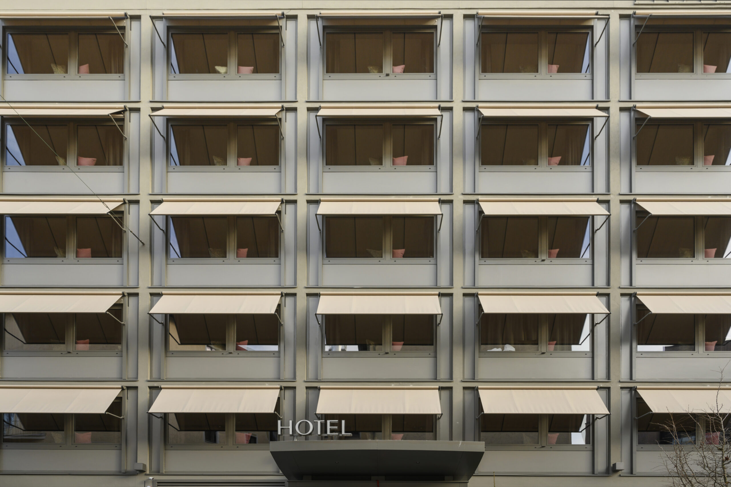 Fassade des JAMS Music Hotel in München mit 54 individuell gefertigten Fallarmmarkisen von Rankl Sonnenschutz