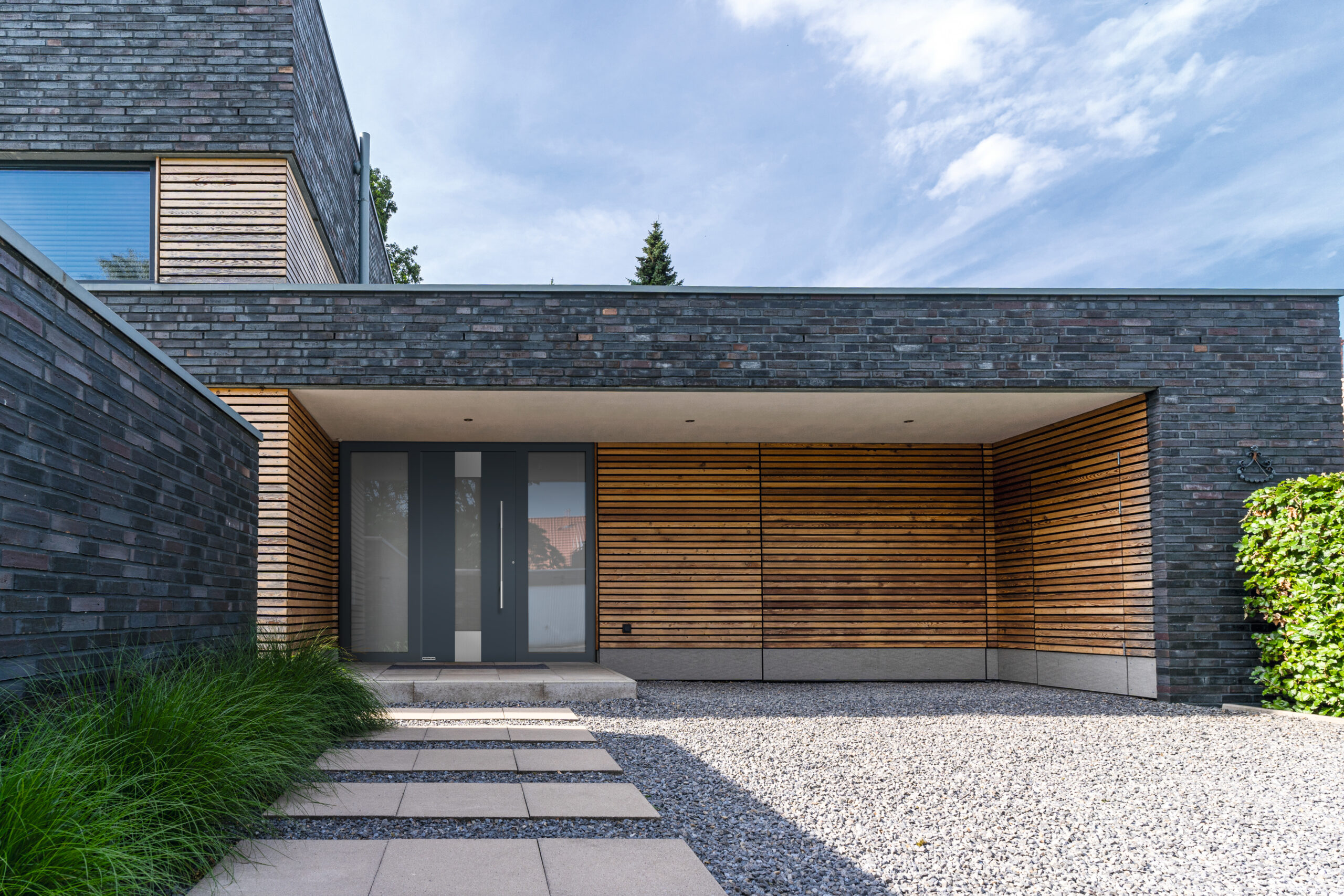 Moderne Haustür in Kombination mit Holz- und Stein-Elementen – sichere und stilvolle Eingangslösungen von Rankl